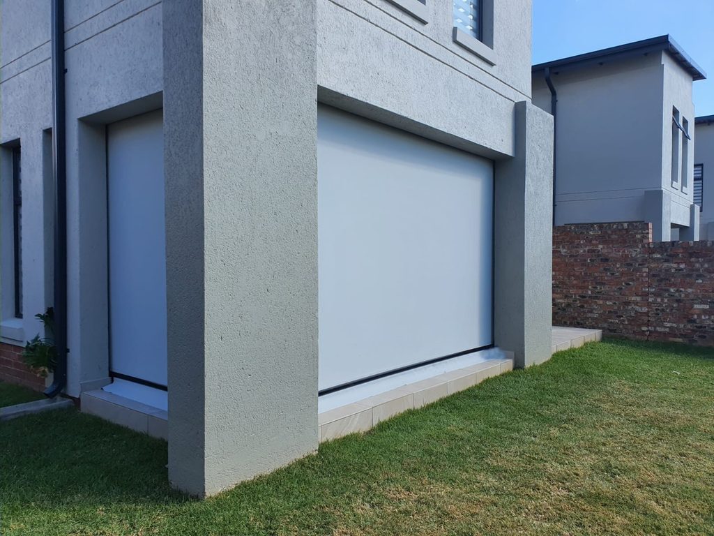 White sheer weave out door roller blinds installed on a covered outdoor patio - outside view